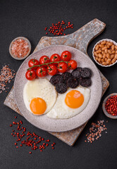 English breakfast with fried eggs, bacon, beans, tomatoes, spices and herbs