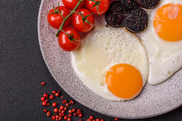 English breakfast with fried eggs, bacon, beans, tomatoes, spices and herbs