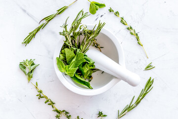 Store up medicinal herbs on white marble background top view