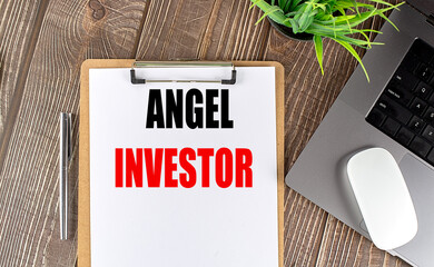 ANGEL INVESTOR text on clipboard paper with laptop, mouse and pen