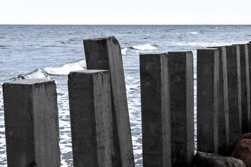 Dark concrete pillars as a part of breakwater structure are at Baltic Sea