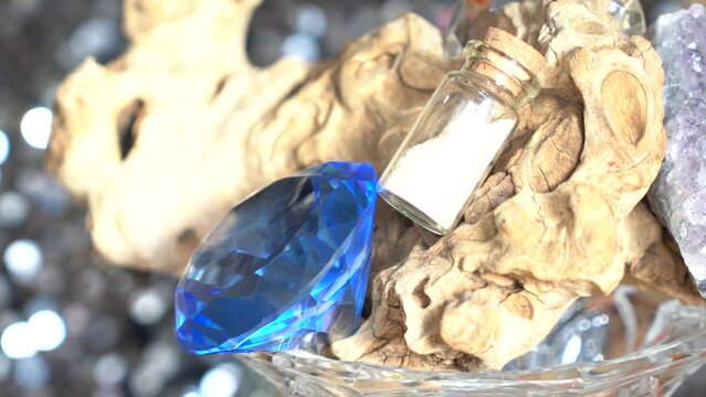 Blue diamond-shape crystal, tiny powder jar, petrified wood and geode amethyst crystal rotating