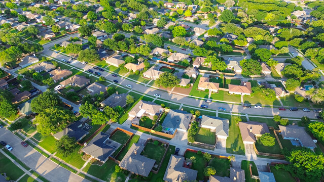 Medium density subdivision with parallel residential streets and back alleys, row of single-family houses lush green trees in suburbs Dallas Fort Worth metro complex, swimming pool, aerial view