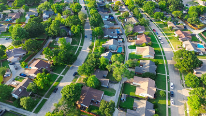 Parallel residential streets with back alleys and row of single-family houses surrounding by lush green trees in suburbs Dallas Fort Worth metro complex, suburban homes swimming pool, aerial © trongnguyen