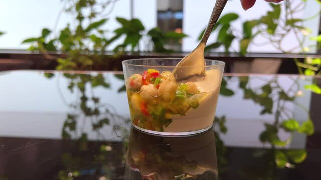 chickpeas Tasting hummus with bread, cracker, cookie. Eating hummus garnished with chickpeas, olive oil, paprika, spices. Hummus or fava, hearty snack of legumes. Lean dish close-up slow motion