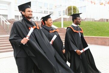 Diverse international students with diplomas at university campus