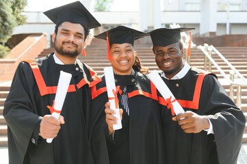 Diverse international students with diplomas attending graduation ceremony, happy multiracial group of students