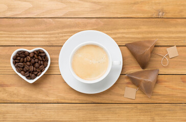 Cup of coffee made using pyramid on wooden background, top view