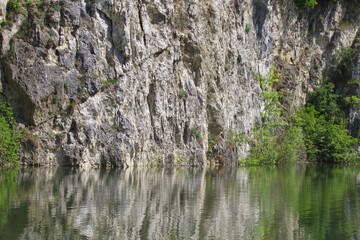 Old quarry lake with rocks reflected in the water