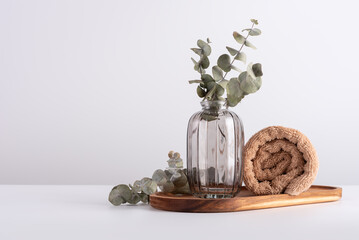 Beautiful eucalyptus branches in glass vase and terry towel