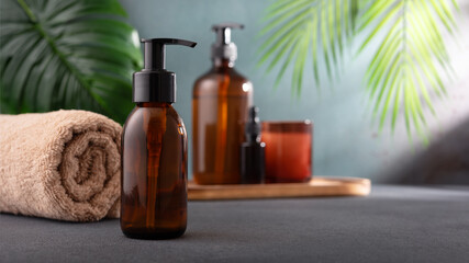 A brown glass dispenser cosmetic bottle for body care product mock-up in tropical spa interior