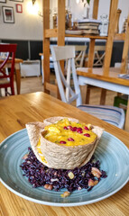 Small blue plate with red lentils on dark rice on wooden table