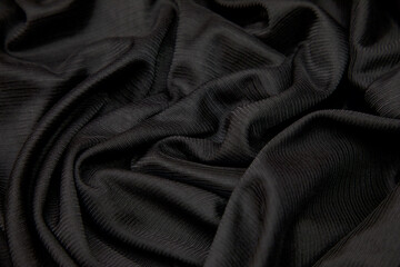 a fabric swat with black texture closeup on a dark background
