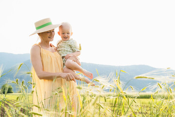 Mother and her little child in nature. Loving mom with her toddler boy at summertime in countryside