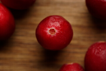 Top view of cranberries arranged on a rustic wooden board