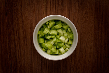 Top view of a white bowl filled with freshly chopped celery