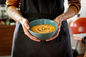 Chef showcasing a tasty butternut squash soup dish