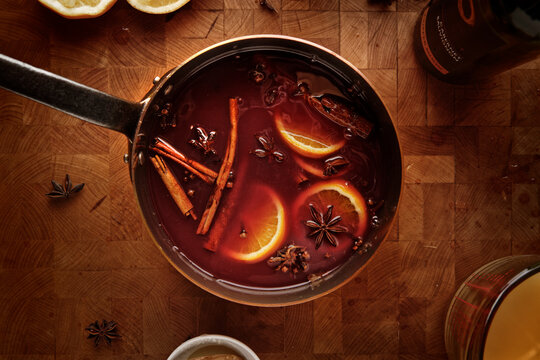 Top view of a pot of mulled wine on a rustic wooden table