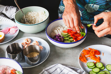 Poke bowl with shrimp prepared by the chef containing white rice, mango, avocado, tomato, etc.