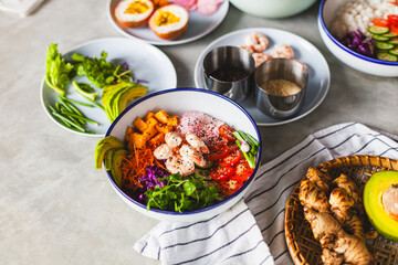Poke bowl with shrimp prepared by the chef containing white rice, mango, avocado, tomato, etc.