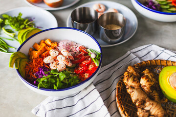 Poke bowl with shrimp prepared by the chef containing white rice, mango, avocado, tomato, etc.