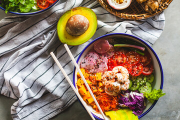 Poke bowl with shrimp prepared by the chef containing white rice, mango, avocado, tomato, etc.