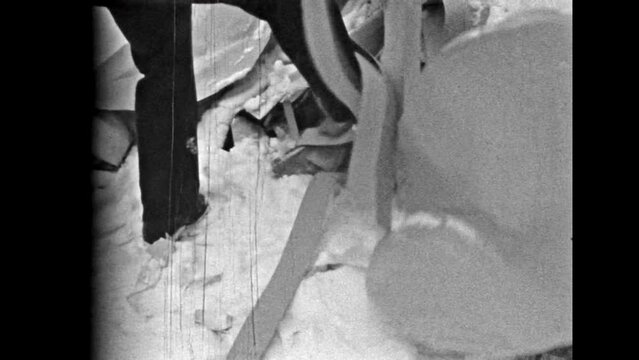 Man rummaging in garbage heap at landfill, close up. Person interested in trash contents. Problems of landfills, recycling. Industrial paper waste. Vintage black white film. Retro 1980s archive