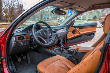 Front seats of the car with orange upholstery and black steering wheel
