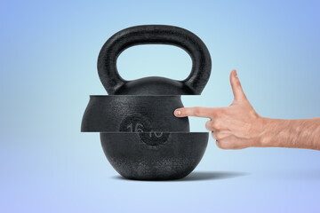 Human hand pointing at floating kettlebell