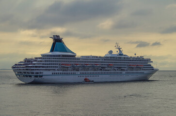 Luxury German cruiseship cruise ship ocean liner Artania sail away departure from Bremerhaven, Germany with pilot and tug boat summer cruise vacation