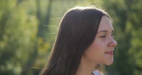 The girl breathes fresh air in nature. Positive mood from good weather and clean environment.