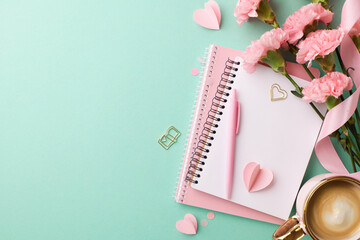 Open notebook with pink pen and flowers on turquoise backdrop. Perfect for office, journaling, or creative projects