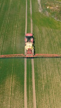 A bird's-eye view of a tractor that irrigates a field. Vertical video