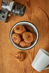 A bowl with seed cookies on a table with a camera