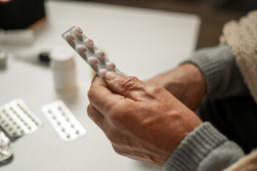 man's hand is full of pills, nutritional supplements or vitamins.