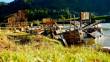Wood water wheel Baler Machine in Agriculture Farm impeller lifted pumping water in river. Wooden Water Baler Machine green garden Farm blades by windy natural. Sustainable Resources Environment © aFotostock