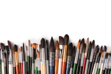 Mix of paint brushes in a row isolated on a white background.