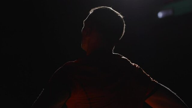 Gymnast Or Marathon Runner Resting After Hard Workout In Stadium, Back View Of Male Silhouette
