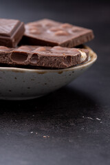 Chocolate cupcake with icing and chocolate bar in Dark lighting,Homemade delicious chocolate muffin on wooden background close-up