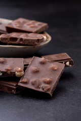 Chocolate cupcake with icing and chocolate bar in Dark lighting,Homemade delicious chocolate muffin on wooden background close-up