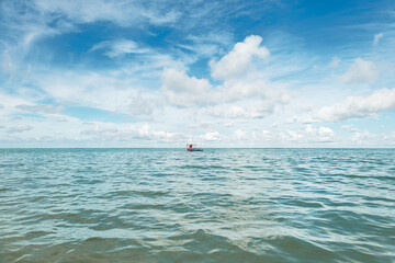  Small boat in the ocean near the coast of a beach in Brazil.