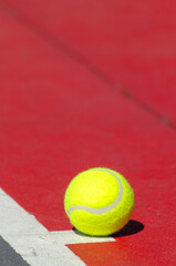 ball on a red hard surface tennis court