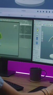 Young 3D designer develops video game, creates character or clothes, works remotely from home on PC and big digital screen with professional software interface and tools for 3D modeling and design.