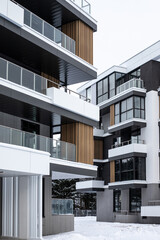 vertical photo of an almost finished residential area with modern white houses in winter