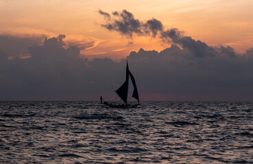 Calm evening on a sandy beach with boat sailing in the distance. Boracay, Philippines.