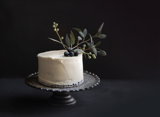 Anniversary naked cake. Celebration sweet food. Floral decoration. Clean dark background.