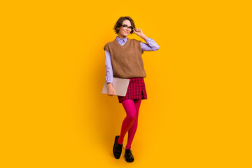 Fototapeta premium Photo portrait of attractive young woman hold netbook touch specs dressed retro office clothes isolated on yellow color background