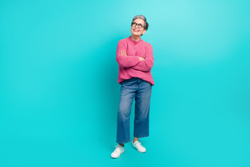 Full length photo of satisfied woman wear pink sweater look at proposition empty space palms folded isolated on teal color background