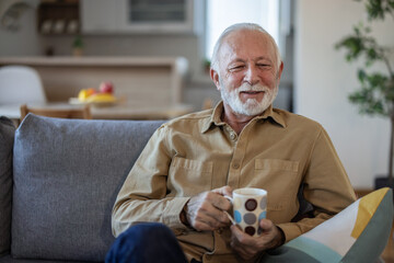 Elderly man, sofa and tea to relax with drink for peace, quiet and me time to start morning in house. Senior men, couch and tea for happiness, thinking and memory from aroma in home living room.