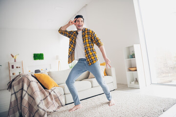 Photo of funky positive man wear checkered shirt dancing showing v-sign indoors house apartment room
